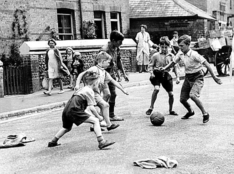 CHILDREN PLAYING FOOTBALL IN THE STREET